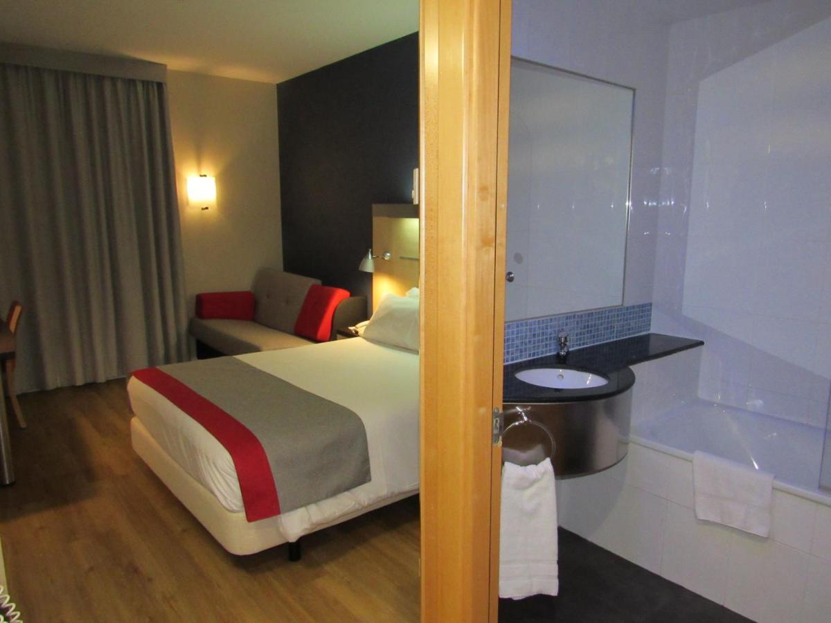 Habitación Doble Estándar con cama doble grande y sofá cama.